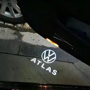 VW Atlas door lights projecting a crisp white Volkswagen Atlas logo onto the ground from the open SUV door.