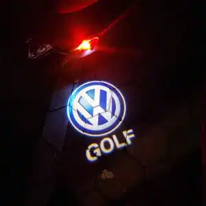 VW Golf door light projector shining a sharp, bright white Volkswagen Golf logo onto the pavement.