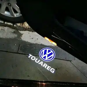VW Touareg door lights projecting a crisp white Volkswagen Touareg logo onto the ground from the open luxury SUV door.